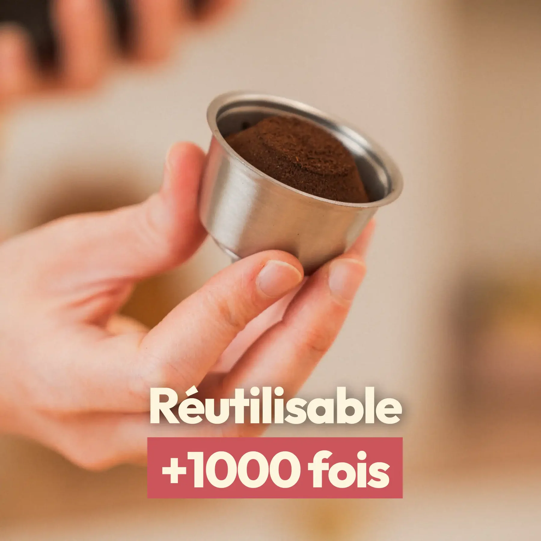 Une main tient une capsule Caps'me réutilisable en inox remplie de café moulu