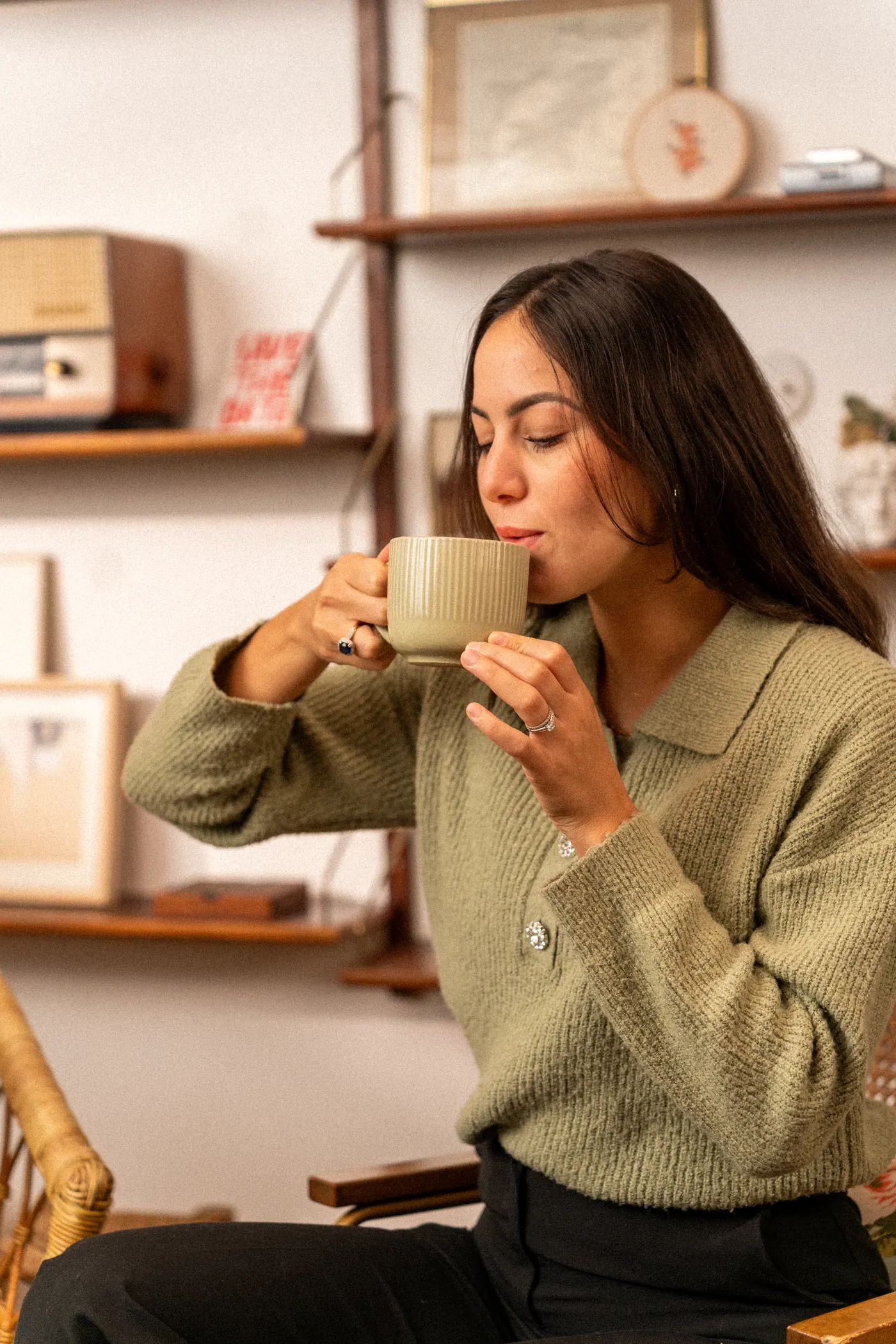 Une femme savoure une tasse de café dans un intérieur cosy