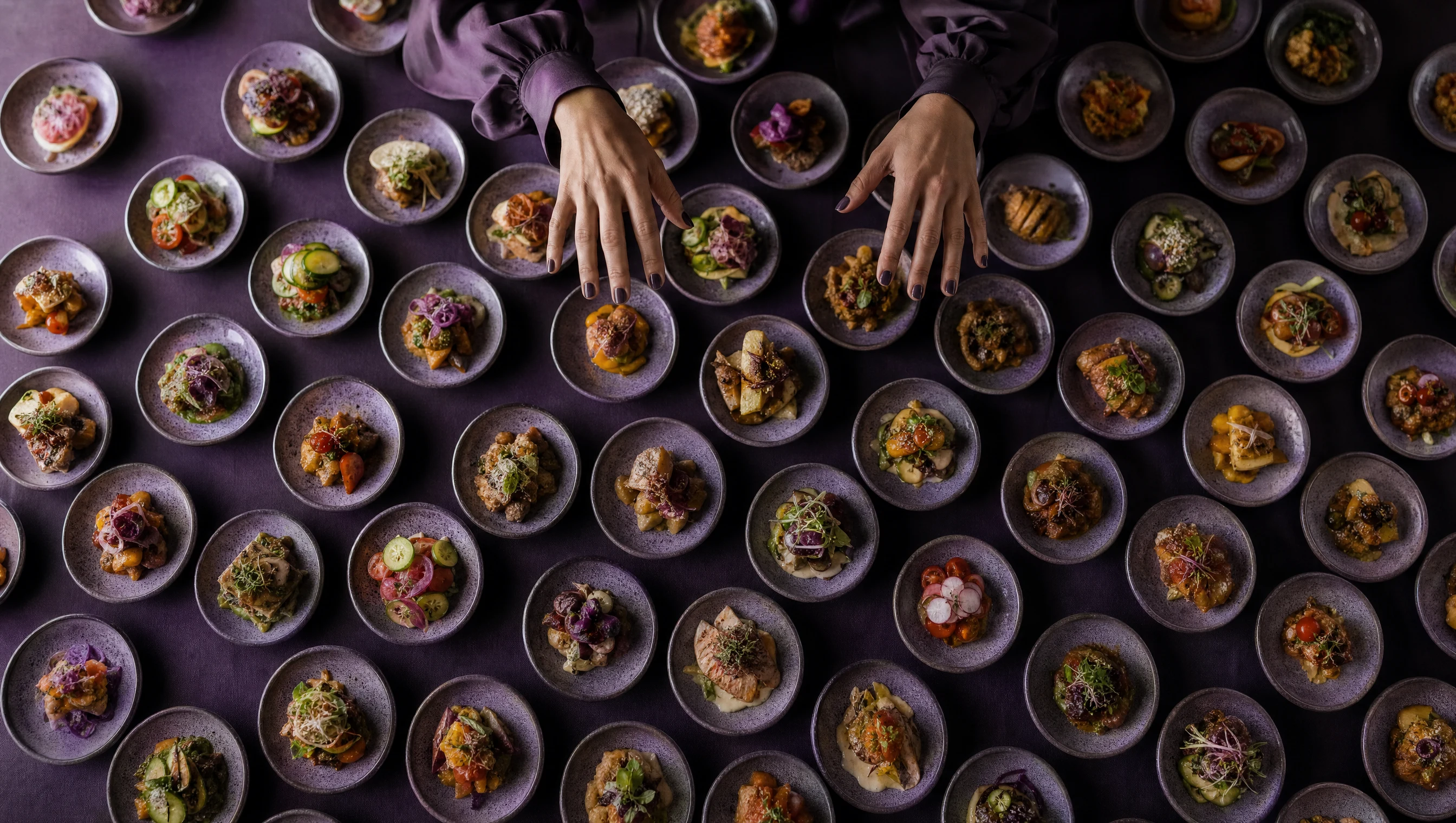Des mains hésitent au-dessus d'une table entièrement couverte de dizaines de plats identiques, incapables de choisir : la paralysie du choix